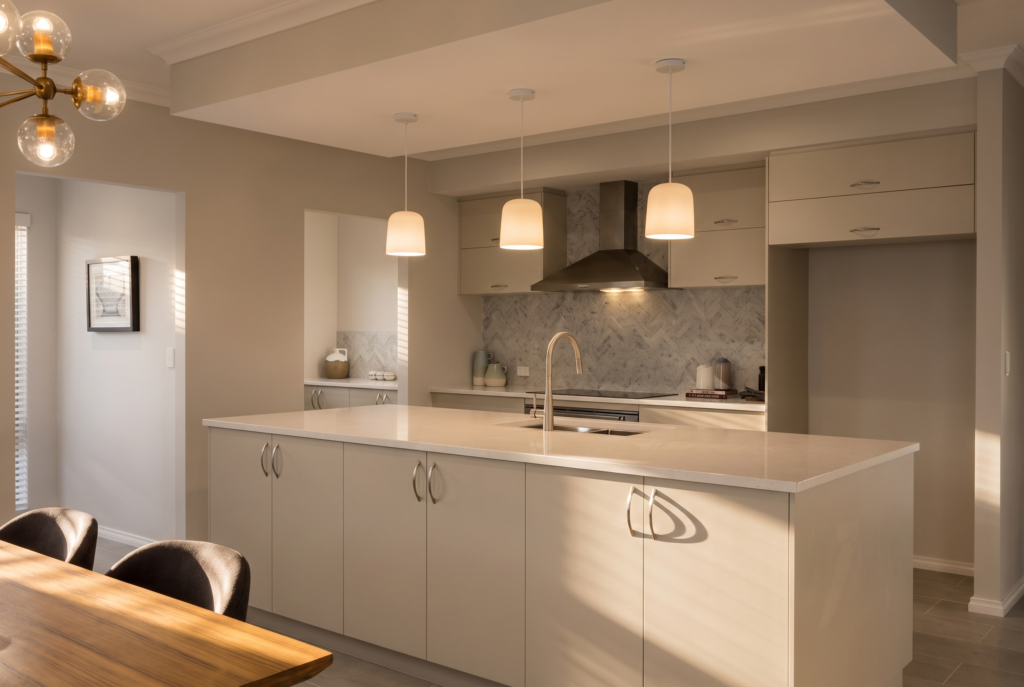 Modern kitchen with a large island, pendant lights, and stainless steel appliances.
