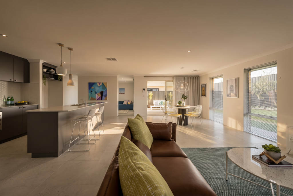 Modern open-plan living area with a kitchen island, dining table, and lounge.
