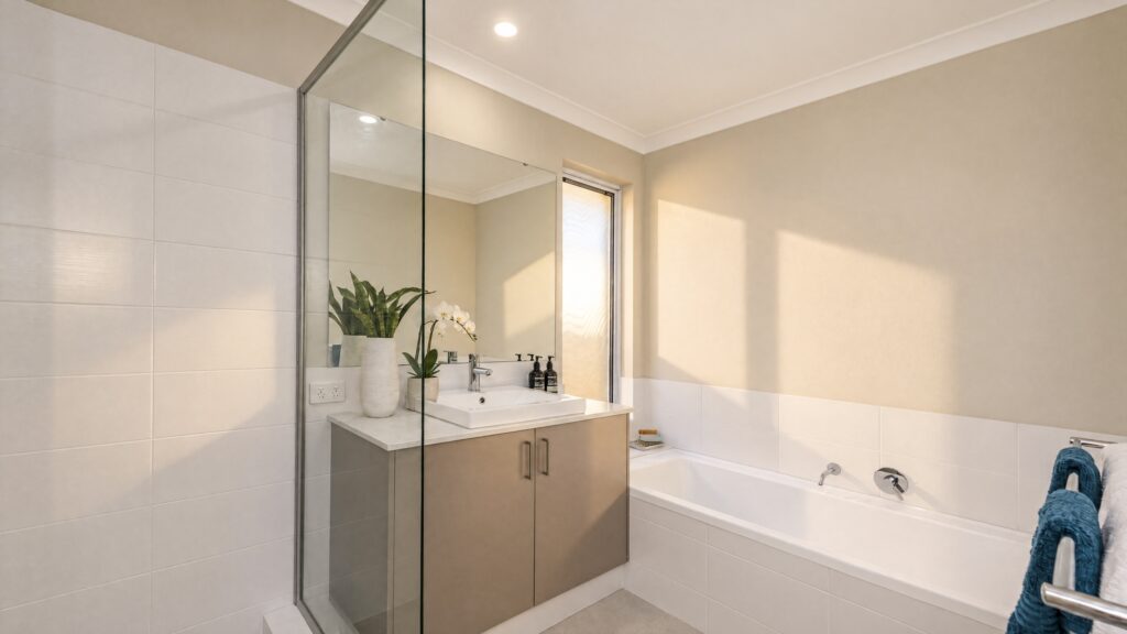 The Gibb River bathroom features a modern vanity, bathtub, and glass-enclosed shower with white tiled walls.