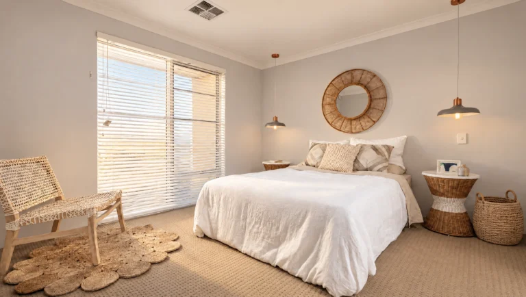 The Gibb River bedroom features a white-linen bed, woven chair, and round mirror.