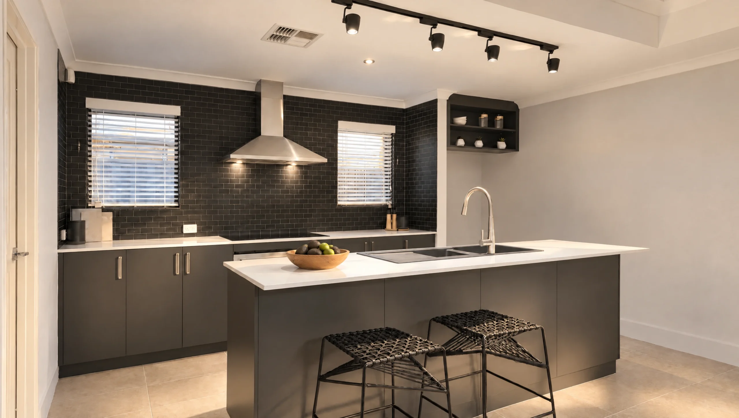 Modern dark grey kitchen with white island, black subway tile backsplash, and stainless steel appliances.