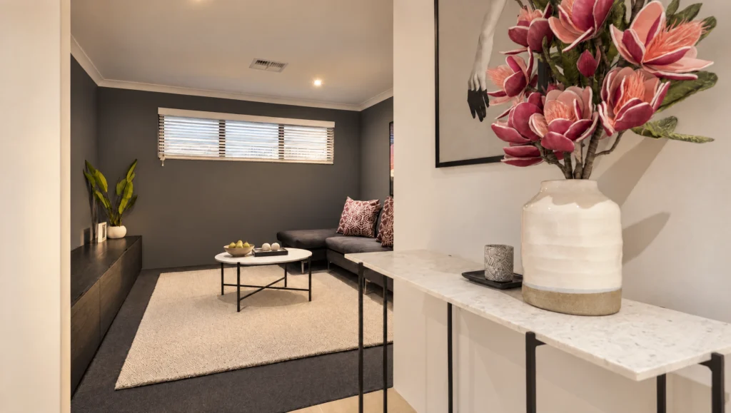 The Hamelin Bay design features a modern living room with a grey sectional sofa and a white coffee table.