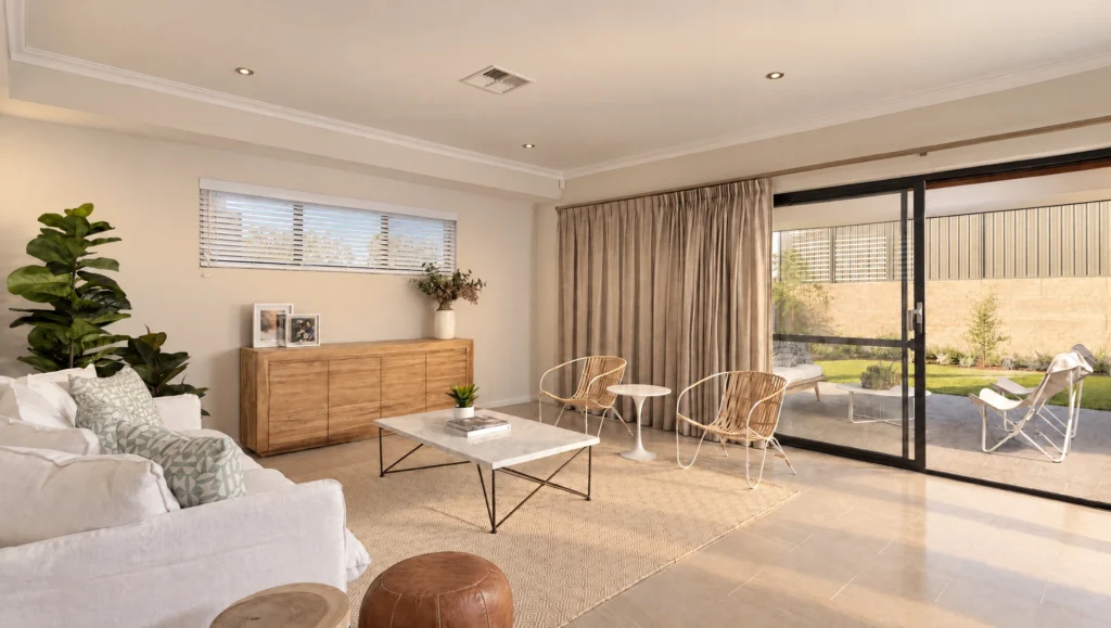 The Ningaloo living room features a white sofa, rattan chairs, and a marble coffee table with backyard access.