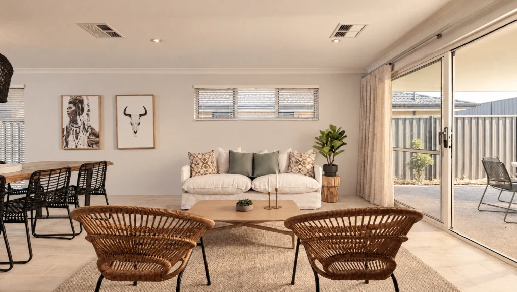 The Pinnacles living room features a white sofa, rattan chairs, and artwork.