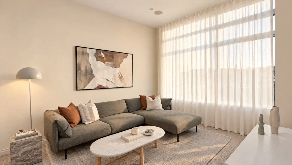 A modern living room features a sectional sofa, marble coffee table, and abstract art above the sofa.