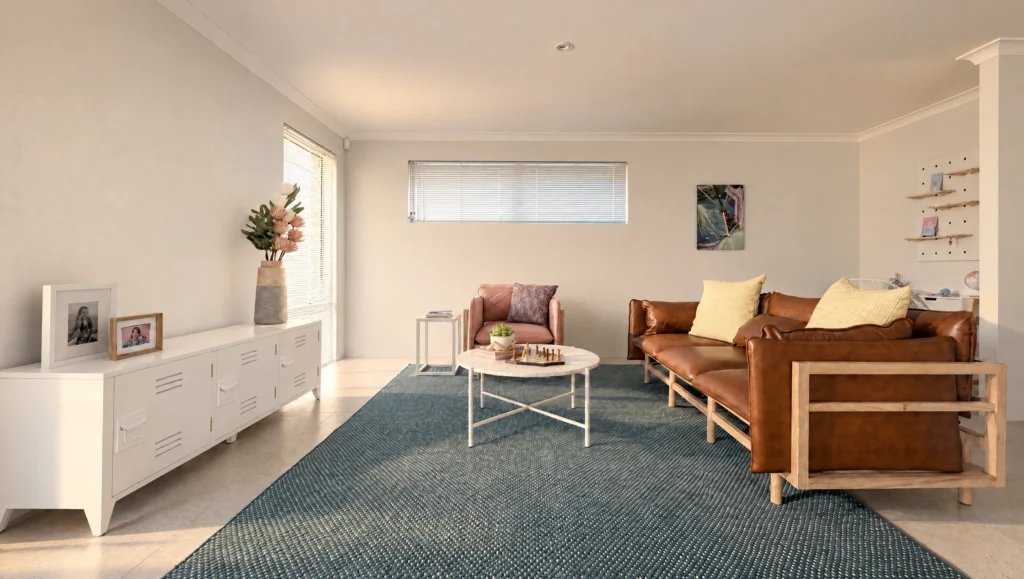 The Yardie Creek living room features a brown leather sofa, pink armchair, and a white coffee table on a blue rug.