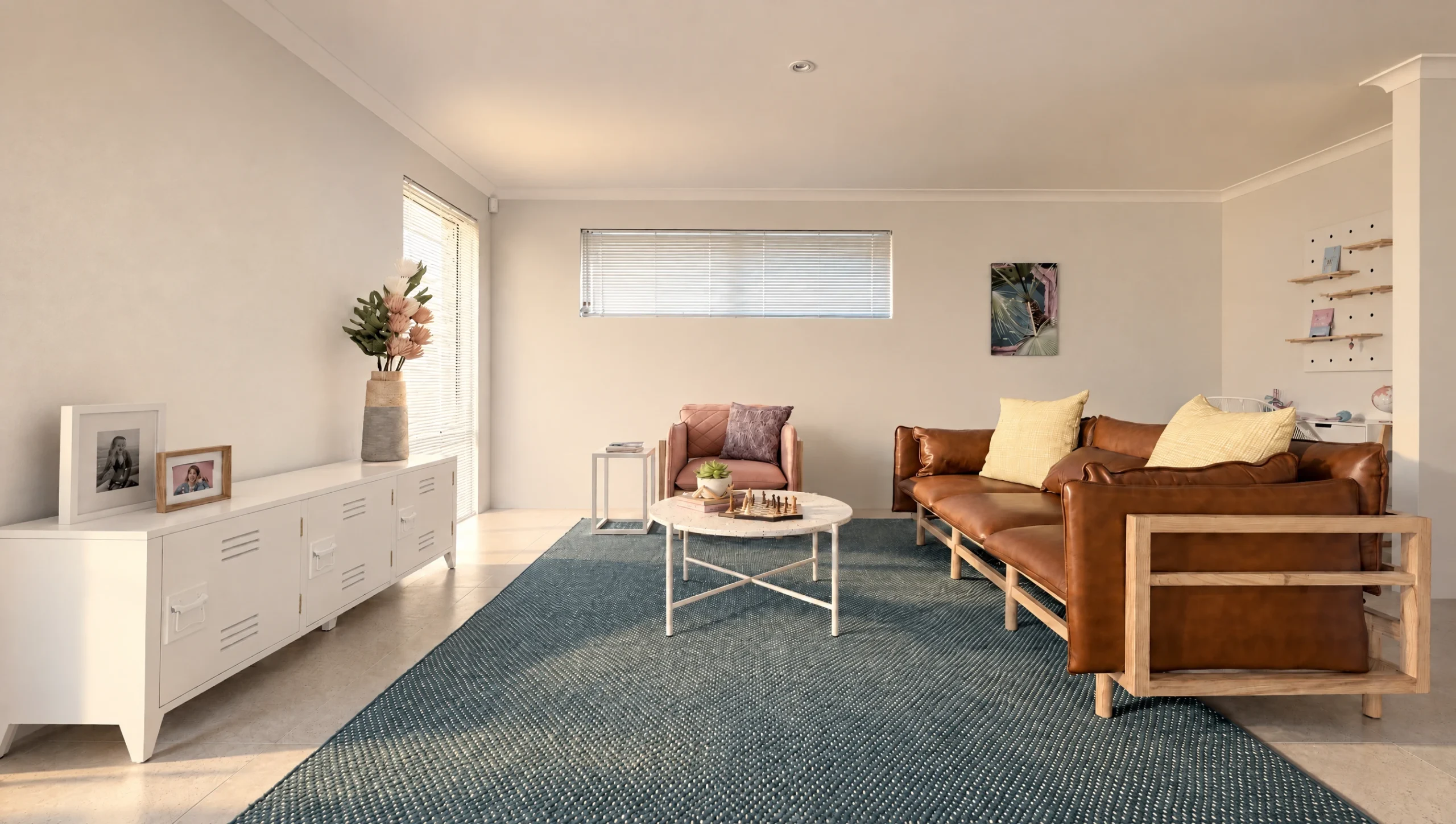 The Yardie Creek living room features a brown leather sofa, pink armchair, and a white coffee table on a blue rug.