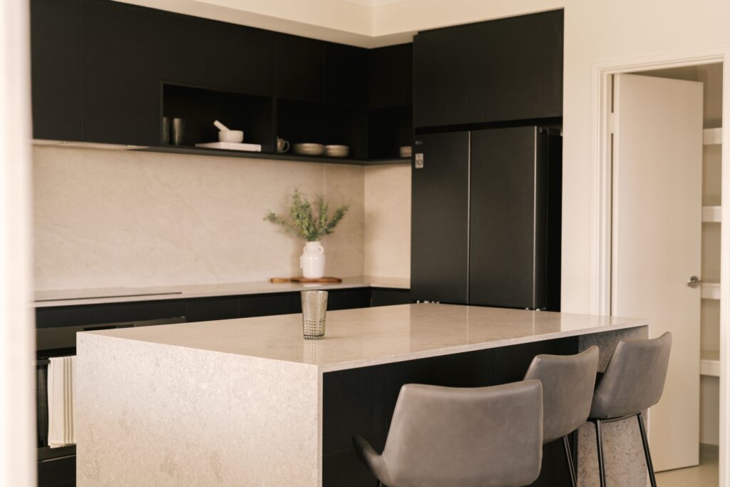Modern black and white kitchen with island and bar stools.