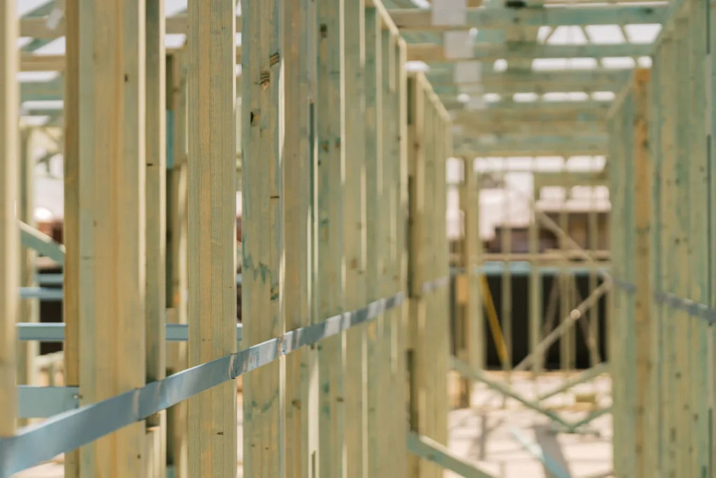 Wooden wall frames and ceiling joists of a house under construction.