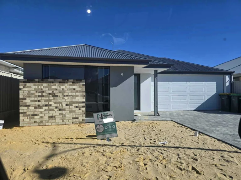 New home construction with brick accents and a garage door, featuring a New Homes WA sign.