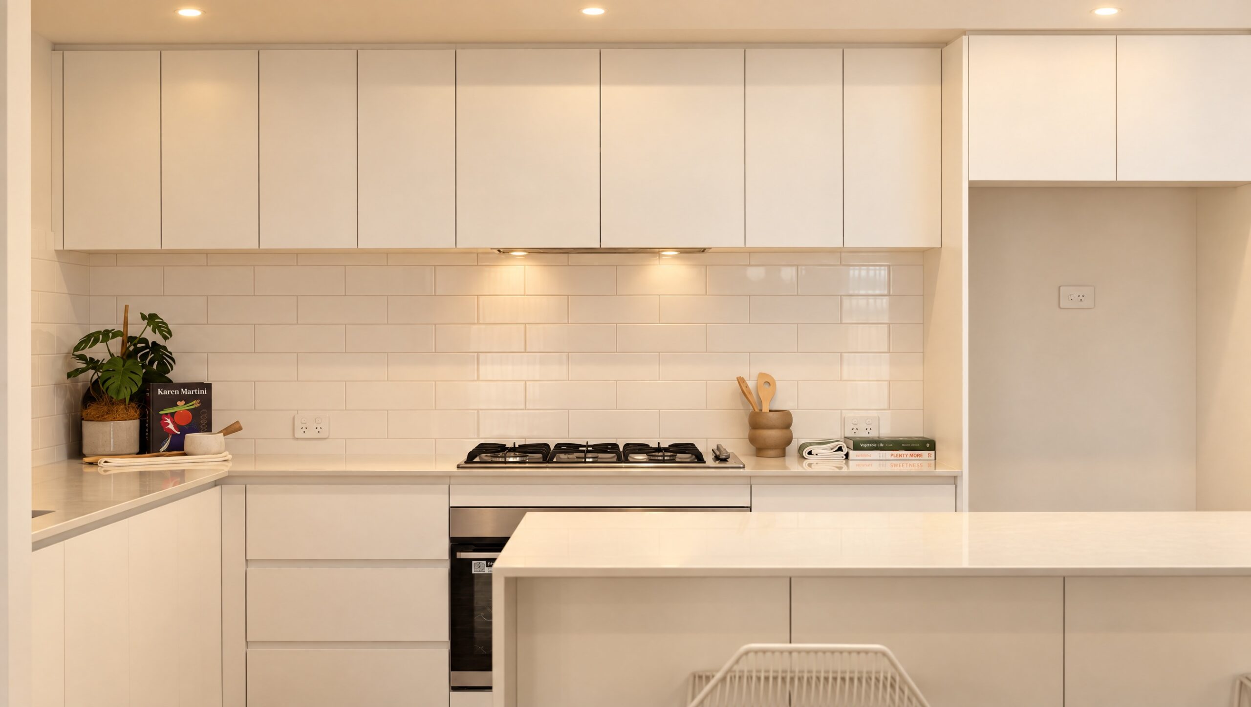 Modern white kitchen with subway tile backsplash and stainless steel appliances.